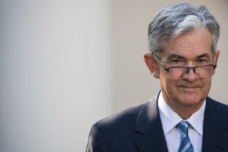 Jerome Powell delivering a speech on economic outlook, impacting crypto and stocks
